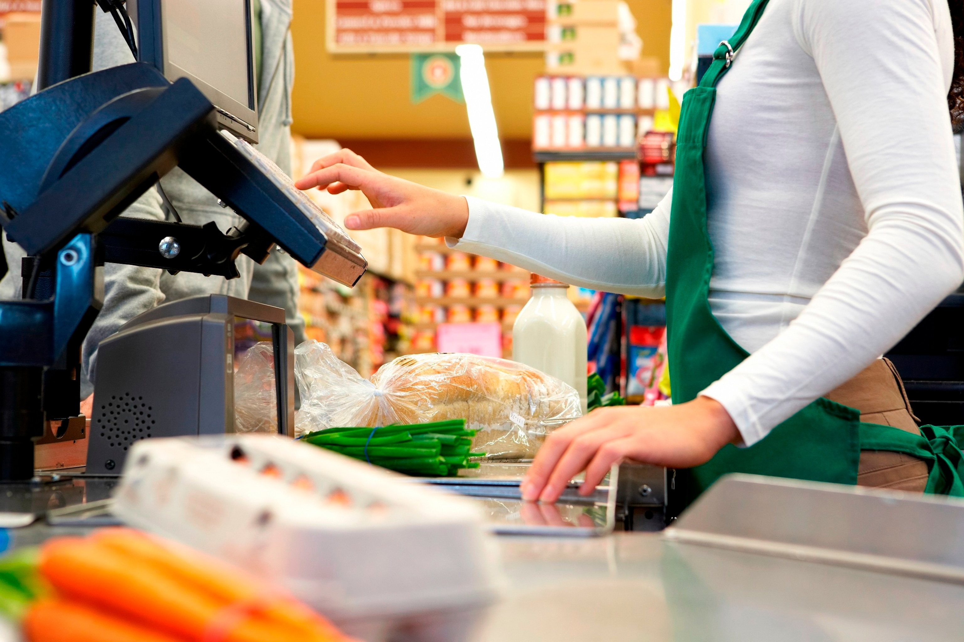 PHOTO: Stock photo of a cashier scanning groceries.